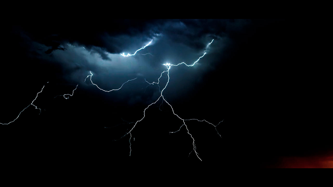 Lightning strike illuminates the night sky.