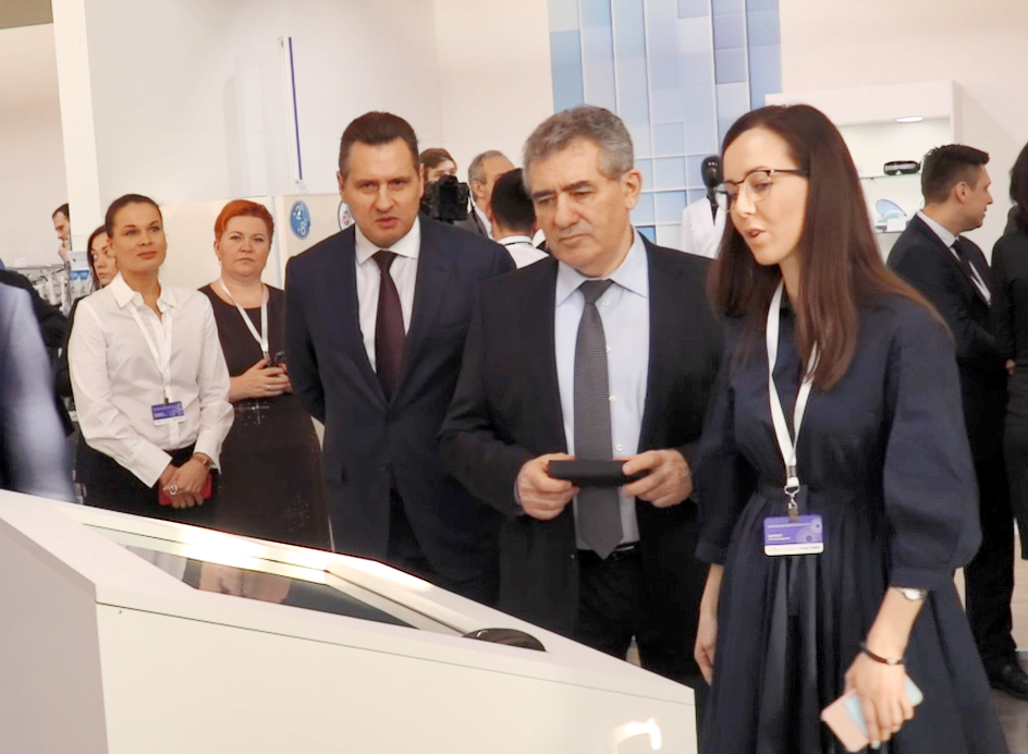 Isaac Kalina (Moscow Government minister and the Moscow City Department of Education Minister) studies a multimedia solution at the exhibition booth.