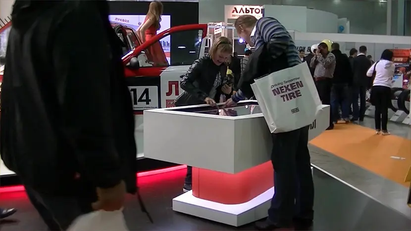 Visitors of the stand at the interactive touch table.