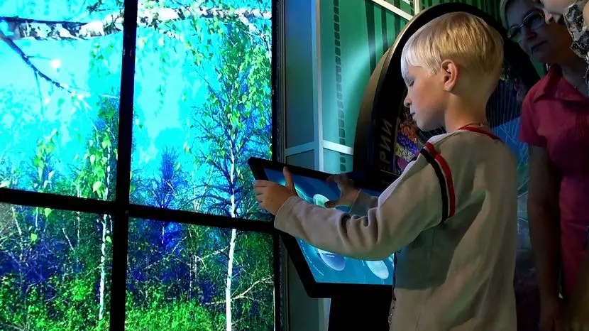 A young guest of the educational center studies the life of a tree.